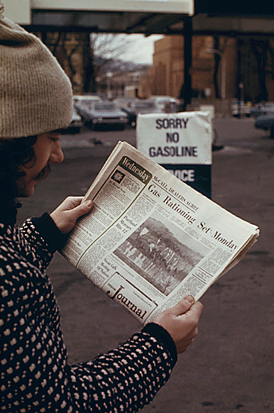 Man reading newspaper article on gas shortage 1973 oil embargo crisis